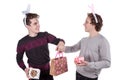 Two happy young men in a rabbit-like ears holding up gift boxes. Isolated on white background Royalty Free Stock Photo