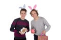 Two happy young men in a rabbit-like ears holding up gift boxes. Isolated on white background Royalty Free Stock Photo