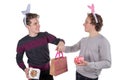 Two happy young men in a rabbit-like ears holding up gift boxes. Isolated on white background Royalty Free Stock Photo