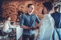 Two happy young men shaking hands while standing in the office Royalty Free Stock Photo