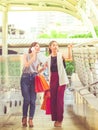 Two happy young woman are holding shopping bags in the city. Royalty Free Stock Photo