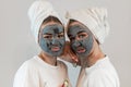 Two happy young woman apply clay mask on face enjoy free time Royalty Free Stock Photo