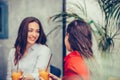 Two happy young women talking and drinking fresh fruit juice in a cafe Royalty Free Stock Photo