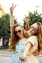 Two happy young women together taking a selfie in the city. Summer day. Royalty Free Stock Photo