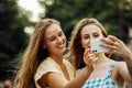 Two happy young women together taking a selfie in the city. Summer day. Royalty Free Stock Photo