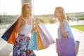 Two happy young women walking on a sidewalk in front of the shopping mall Royalty Free Stock Photo