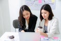 Two hardworking asian young female entrepreneurs working together on a laptop computer reading the screen with serious face Royalty Free Stock Photo