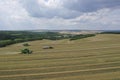 Two harvesters harvest ripe golden wheat in a grain field. Agricultural work in summer. John Deere green yellow combine harvester