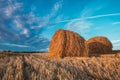 Two hay bales on field in cloudy weather. Royalty Free Stock Photo