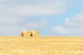 Haystacks in a field covered in the grass under a cloudy sky and sunlight- cool for wallpapers Royalty Free Stock Photo