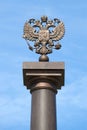 Two-headed Russian eagle on top of a column against a blue sky. Fragment of the monument of military glory