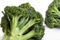 Two heads of broccoli lie on a white background