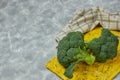 A couple of buds of healthy salad are on the yellow Board. fresh green broccoli. vertical kind of green vegetable flower. healthy Royalty Free Stock Photo