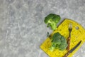 A couple of buds of healthy salad are on the yellow Board. fresh green broccoli. vertical kind of green vegetable flower. healthy Royalty Free Stock Photo