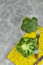 A couple of buds of healthy salad are on the yellow Board. fresh green broccoli. vertical kind of green vegetable flower. healthy Royalty Free Stock Photo