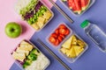 Two healthy asian-style plant-based lunch boxes knolled together on blue and pink background Royalty Free Stock Photo