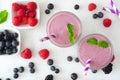 Two healthy berry smoothies, top view table scene over white marble