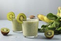 Two healthy detox smoothie kiwi, banana, spinach in glasses on light blue background with fresh ingredients, Diet and weight loss Royalty Free Stock Photo