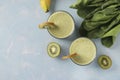 Two healthy detox smoothie kiwi, banana, spinach in glasses on light blue background with fresh ingredients, Diet and weight loss Royalty Free Stock Photo