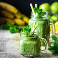 Two healthy green smoothies with spinach, banana, orange, apple and mint in glass jar and ingredients. Detox, diet, healthy, Royalty Free Stock Photo