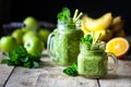 Two healthy green smoothies with spinach, banana, orange, apple and mint in glass jar and ingredients. Detox, diet, healthy, Royalty Free Stock Photo