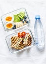 Two healthy office lunch box with sweet, savoury food. Boiled egg, avocado, tuna spinach cheese sandwiches, fruit and bottle Royalty Free Stock Photo