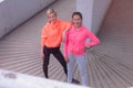 Two healthy young female sporty women prepairing for running in morning on street. Runner training outdoors in morning