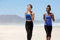 Two healthy young women running on the beach Royalty Free Stock Photo