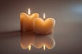 Two heart candles burning with reflection in warm light Royalty Free Stock Photo