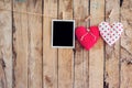 Two heart and photo frame hanging on clothesline rope with wooden background. Royalty Free Stock Photo