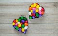 Two heart shaped cookie cutters with jelly beans on wood background Royalty Free Stock Photo