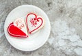 Two heart shaped cookies and a plate on a gray marble counter Royalty Free Stock Photo