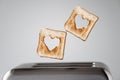 Two Heart shaped on roasted toasted bread in a toaster. Breakfast preparation on Valentine`s Day. symbol sign of love.