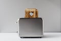 Two Heart shaped on roasted toasted bread in a toaster. Breakfast preparation on Valentine`s Day. symbol sign of love.