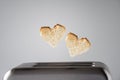 Two Heart shaped on roasted toasted bread in a toaster. Breakfast preparation on Valentine`s Day. symbol sign of love.