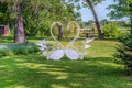 Two heart-shaped swans on a green lawn on an Alley of Lovers in Trostianets Park