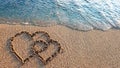 Two hearts drawn on brown sand of paradise beach Royalty Free Stock Photo