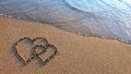 Two hearts drawn on brown sand of paradise beach Royalty Free Stock Photo