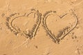 Two hearts drawn in the sand on sea beach Royalty Free Stock Photo