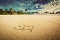 Two hearts drawn on sand of a tropical beach. Vintage Royalty Free Stock Photo