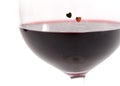 Two hearts on a glass with red wine on white background Royalty Free Stock Photo