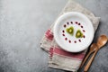 Two hearts from kiwi on a white ceramic plate on a gray concrete or stone background. Postcard for Valentine`s Day. Selective Royalty Free Stock Photo