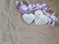 Two hearts with lavender picture and purple ribbon on the background of old paper. Soft focus, background mode