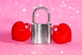 Two hearts locked together with a padlock on pink Royalty Free Stock Photo