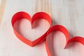 Two hearts made of ribbon on wooden background. Royalty Free Stock Photo