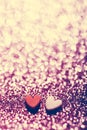 Two hearts on pink glittery background