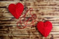 Two hearts of red color tied by a thread lie on a wooden background Royalty Free Stock Photo