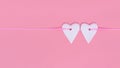 Two hearts side by side on pink ribbon on pastel pink color background. Concept for Valentines Day, for lovers.