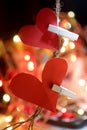 Two hearts on a string. Red blank paper with love symbol shape hanging on rope with white wooden clips and colorful bokeh lights. Royalty Free Stock Photo
