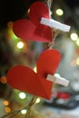 Two hearts on a string. Red blank paper with love symbol shape hanging on rope with white wooden clips and colorful bokeh lights. Royalty Free Stock Photo